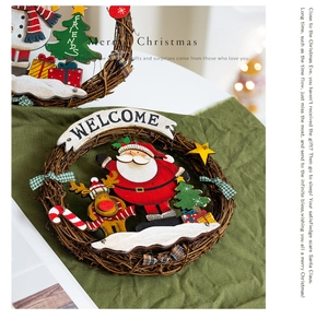 Detail of a handmade Christmas wreath with a wooden Santa, reindeer, and Welcome sign