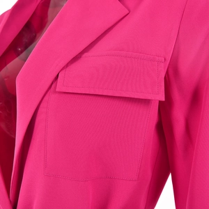 Détail d'un blazer rose avec revers structuré et une poche à rabat classique