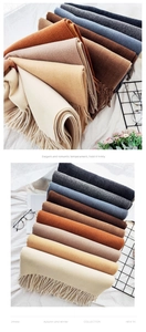 Close-up of thick cashmere-like scarf texture with delicate fringe in warm winter colors