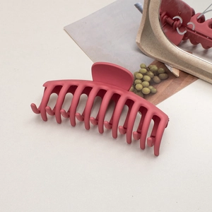 Detail of large matte burgundy claw clip with multi-teeth design for thick hair