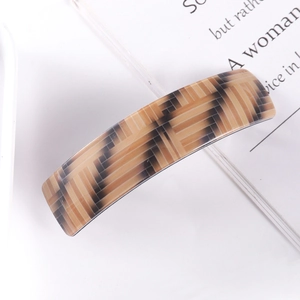 Macro shot of rectangular acetate hair clip with brown and black geometric weave pattern