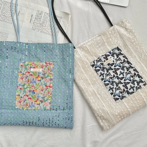 Detailed top view of pearlescent canvas tote bags with lace texture and floral patch pockets