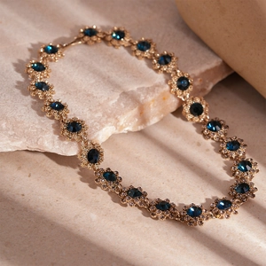 Macro detail of vintage floral gold necklace with blue crystals and sparkling diamonds
