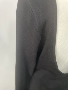 Detail shot of black ribbed knit dress collar and shoulder stitching on a white mannequin