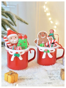 Detail of Christmas mugs ornaments with Santa and Gingerbread Man in festive snowy scene
