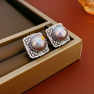Detailed view of grey pearl earrings with silver square settings and zircon embellishments