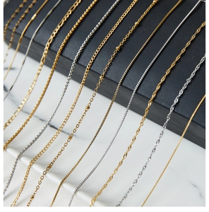 Close-up of gold and silver stainless steel water wave and box chains for necklaces