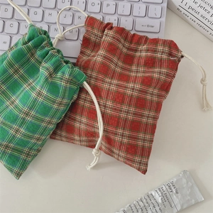 Macro view of red and green plaid drawstring pouches made of cotton linen fabric