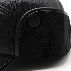 Detail view of winter ear flap hat with black leather texture and soft faux fur lining
