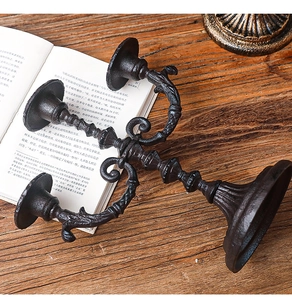 Detail view of vintage three-arm iron candlestick on a rustic wooden table setup