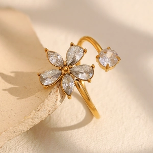 Bague ouverte fleur plaquée or 18 carats avec zircons sur un support en pierre
