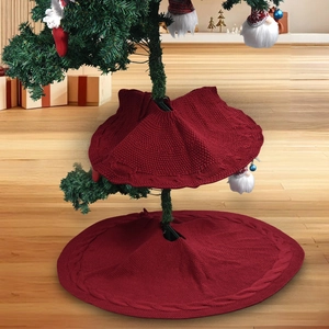 Classic red cable knit Christmas tree skirt used as a festive base decoration for holidays