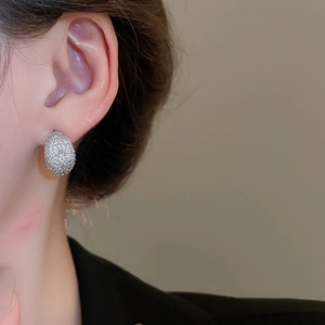 Macro view of silver-plated earring featuring micro-pave sparkling cubic zirconia stones