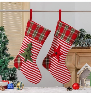 Detail of knitted Christmas stockings with green tree and red star decorations and hanging loops