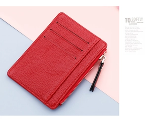 Macro shot of red pebble grain leather card holder with multiple slots and zip pocket