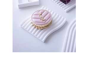 Detailed view of cosmetic compact on a wavy white gypsum storage tray for photography