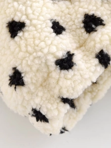 Detaillierte Makroansicht der weichen Fleece-Struktur mit schwarzen Polka-Dot-Punkten