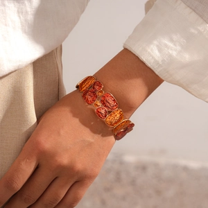Close-up of geometric enamel elastic bracelet with amber resin on model's wrist