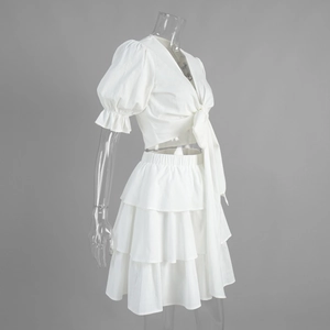 Detail view of white puff sleeve tie-front crop top and layered ruffle cake skirt set
