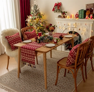 Detailed close-up of a festive red table runner with reindeer and snowflake patterns