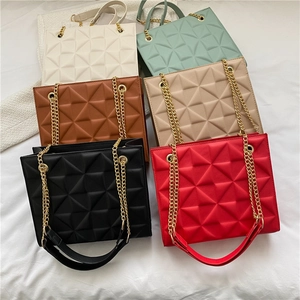 Flat lay of rectangular crossbody bags with 3D geometric patterns and gold chain straps