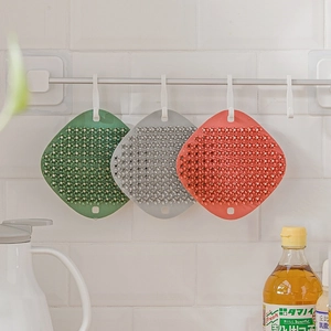 Three-piece multi-purpose silicone dish brushes in green, grey and coral on a wall rack