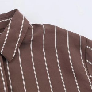 Detail of classic brown striped shirt featuring vertical stripes and a crisp lapel collar