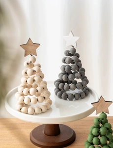 Detail of Nordic wooden beaded Christmas tree on a white ceramic tray with star top
