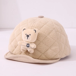 Detail of warm beige quilted fleece baby hat featuring a plush bear doll and corduroy brim