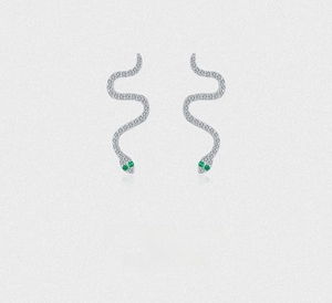 Detailed macro of S925 sterling silver snake stud earrings with green gemstone eyes
