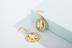 Detailed close-up of gold stainless steel round earrings with pavé crystals and boy silhouette
