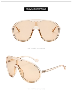 Macro detail of oversized brown champagne sunglasses with integrated frame and metal bridge