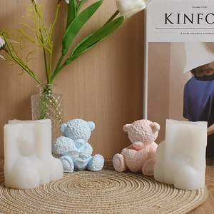 Detail view of 3D bear silicone mold and finished candles with fuzzy texture on a woven mat