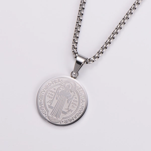 Detailed close-up of a silver stainless steel Saint Benedict religious medal pendant