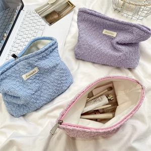 Three-piece set of bubble textured cosmetic bags in blue, purple, and pink soft fabric