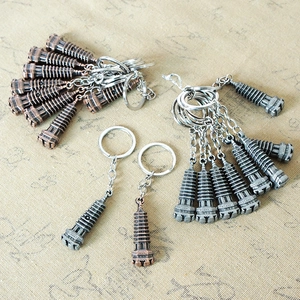 Detailed view of metal pagoda-shaped pendant keychains in bronze and silver finishes