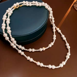 Gros plan d'un collier de perles double couche avec fermoir OT sur boîte à bijoux