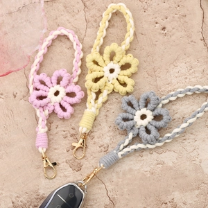 Close-up of handmade woven flower lanyards with golden lobster clasps for keys