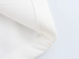 Dettaglio della trama in maglia bianca e cuciture ordinate sul set a due pezzi