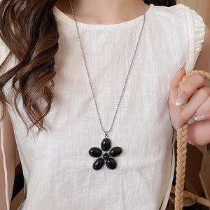 Detailed view of vintage resin flower pendant necklace on model with silver ball chain