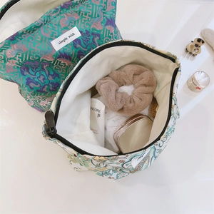 Detailed top view of jacquard makeup bags showing interior capacity and floral patterns
