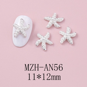Detailed view of silver starfish nail charms with faux pearls on pink background