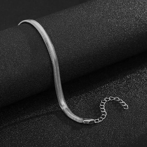 Detailed close-up of a flat silver snake chain bracelet with high-shine metallic texture