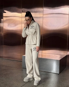 Detail of Girls Club embroidery on cream drawstring jacket and wide-leg sweatpants set