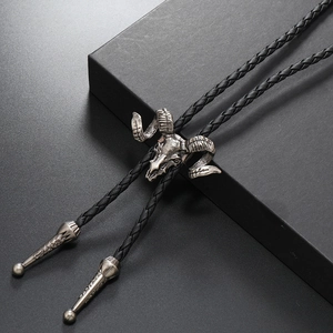 Close-up of a silver metal ram skull bolo tie with black braided leather cord and tips