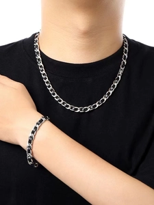 Detail of woven chain necklace and bracelet set in silver and black on male model