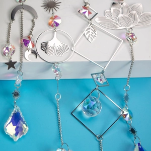 Macro detail of silver suncatchers with crystal prisms and lotus moon patterns