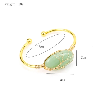 Detail view of handmade copper wire-wrapped oval green gemstone tree of life cuff bracelet