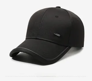 Dettaglio del berretto da baseball nero con profilo laterale e logo metallico