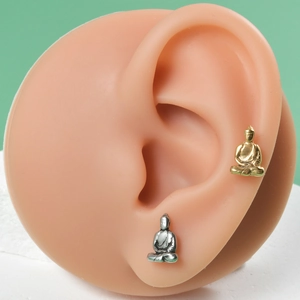 Buddha shaped stainless steel stud earrings in gold and silver finish on ear model